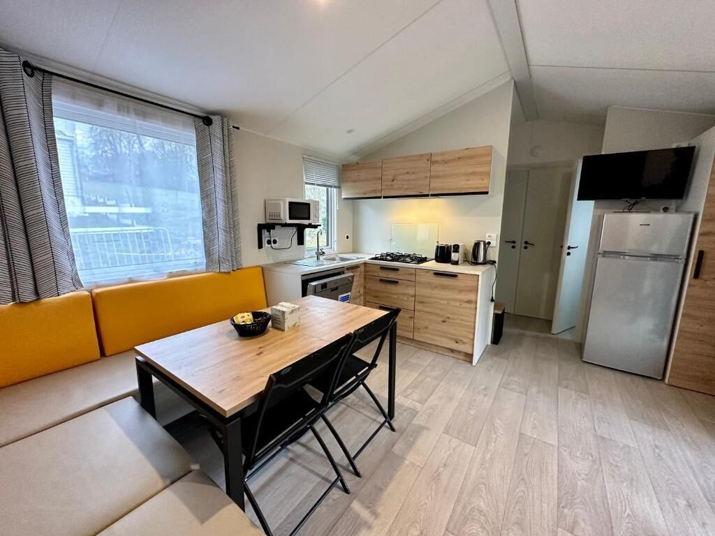 A compact kitchen with a dining area, a microwave, a stove, and a refrigerator.