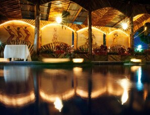 An indoor pool area with a table and chairs, surrounded by a covered seating area with a mural. - Hotel Casa Antigua (Rio Segundo)