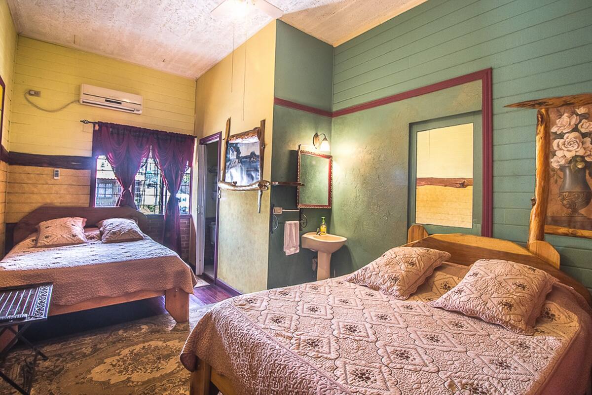 Une chambre avec deux lits, un lavabo et un appareil de climatisation.