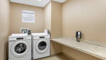 Zona de lavandería para huéspedes con dos lavadoras Whirlpool, una encimera y un teléfono.