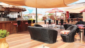 An outdoor bar area with wicker furniture and a bar counter. - The Matola Hotel (Matola)