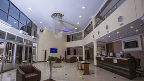 A spacious lobby with a reception desk, seating area, and a large chandelier. - The Matola Hotel (Matola)