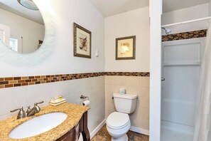 A bathroom with a sink, toilet, and shower.