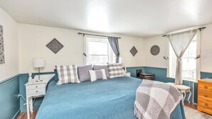 Une chambre à coucher avec un grand lit, une table de chevet, une chaise et une commode.