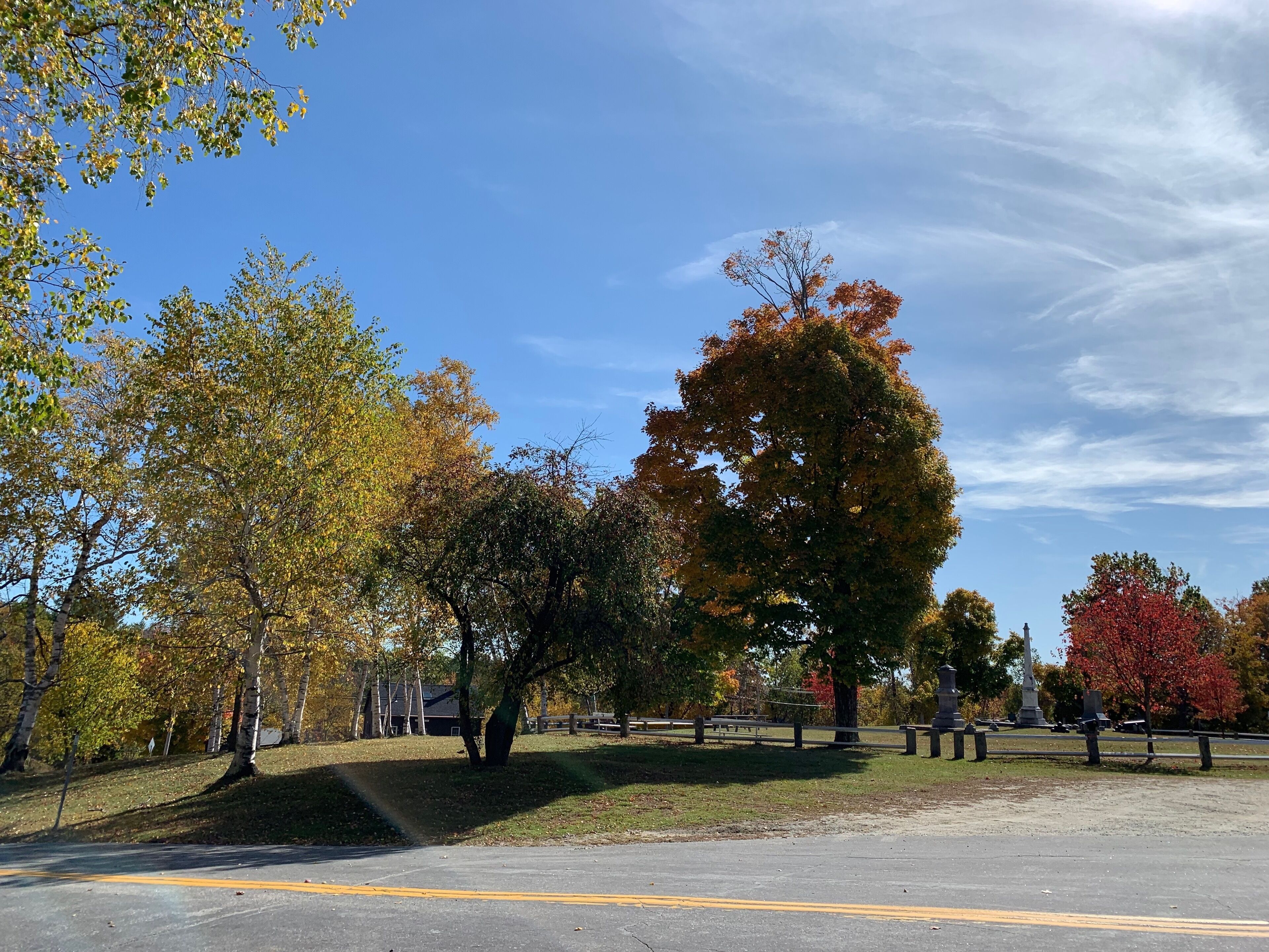 A parking lot with trees displaying autumn foliage.