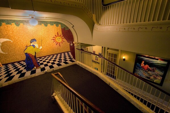 A staircase with a checkered floor, a mosaic wall, and a railing. - McMenamins Grand Lodge (Forest Grove)