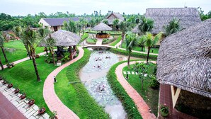 A resort with thatched-roof structures, a central water feature, and well-maintained gardens. - The Island Lodge (Thoi Son)