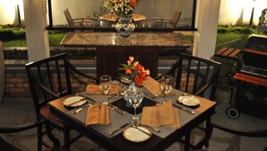 A dining table set for four with a vase of flowers, wine glasses, and cutlery. - Cocoon Hills (Nuwara Eliya)