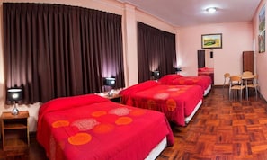 A hotel room with three beds, each with a red bedspread, wooden floors, and a painting on the wall. - Colon Plaza Hotel (Ica)