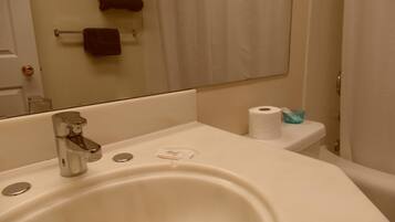 Ein Badezimmer mit Waschbecken, Spiegel und Toilette.