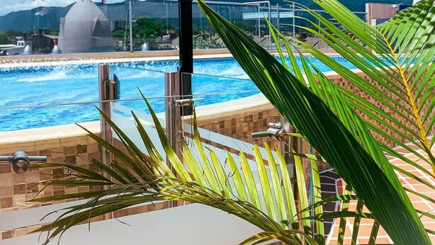 A pool area with a view of mountains and a dome structure in the background. - Hotel Hacaritama Colonial (Villavicencio)