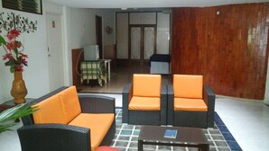 A room with wicker furniture, a small table, and a decorative vase. - Hotel Napolitano (Villavicencio)
