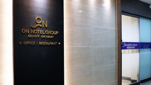 Entrada d'hotel amb un cartell que indica On Hotel Group, On City i On Smart.