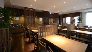 A restaurant with wooden furniture, high ceilings, and recessed lighting. - Hotel Route-Inn Annaka (Annaka)