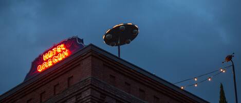 A hotel sign with the name "HOTEL OREGON" in bright red neon lights.