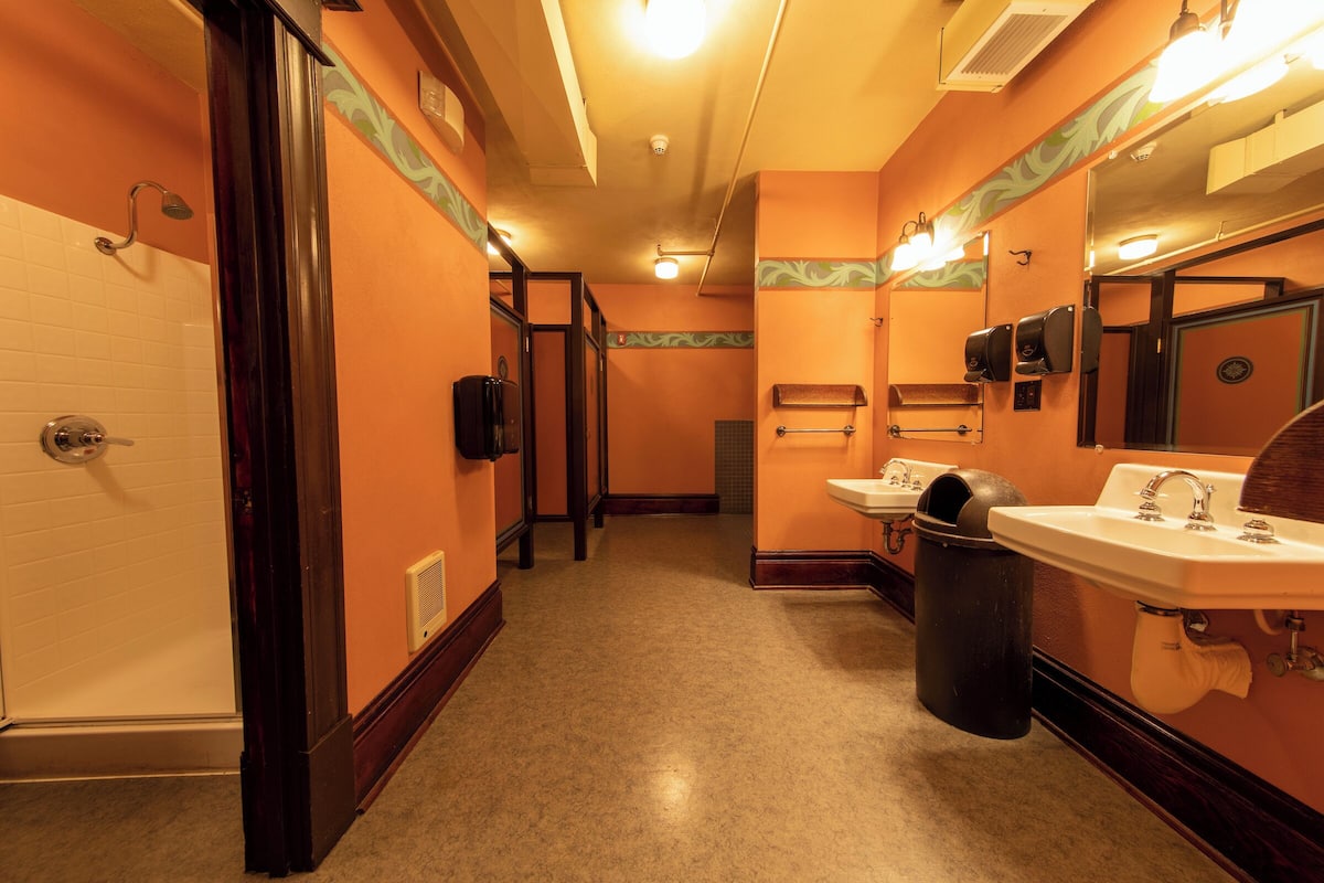 A hotel bathroom with a shower, toilet, and sink.