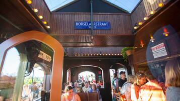A crowded train station with wooden architecture and a sign reading "Borselarestraat."