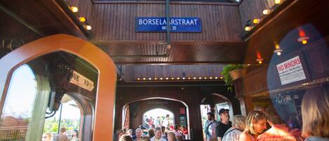 A crowded train station with wooden architecture and a sign reading "Borselarestraat."