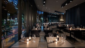 A modern restaurant with tables set for dining, large windows offering a view of the city at night. - Shilla Stay Mapo Hongdae (Seoul)