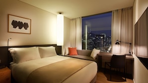 A hotel room with a large bed, a desk, and a view of the city at night. - Shilla Stay Mapo Hongdae (Seoul)