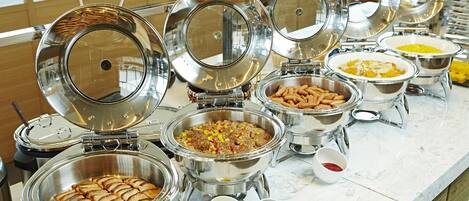 A buffet with various food items and condiments.