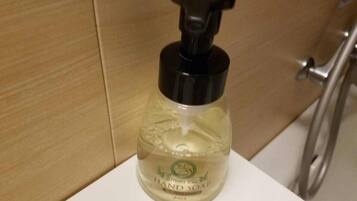 A clear bottle of hand soap on a white surface.