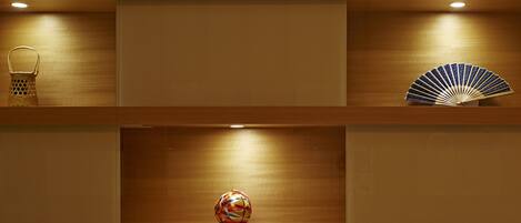 A wooden shelf with a basket, a decorative fan, and a colorful spherical object.