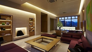 A modern hotel lobby with a seating area, a fireplace, and a view of the mountains. - Candeo Hotels Matsuyama Okaido (Matsuyama)