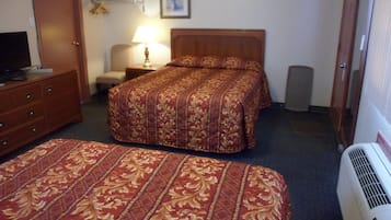 Habitación de hotel con dos camas, televisión, lámpara y calefacción.