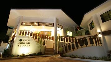 Vista frontal de la propiedad por la tarde o noche