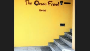 A yellow wall with the sign "The Ocean Front Hotel" and a staircase leading up. - The Ocean Front (Colombo)
