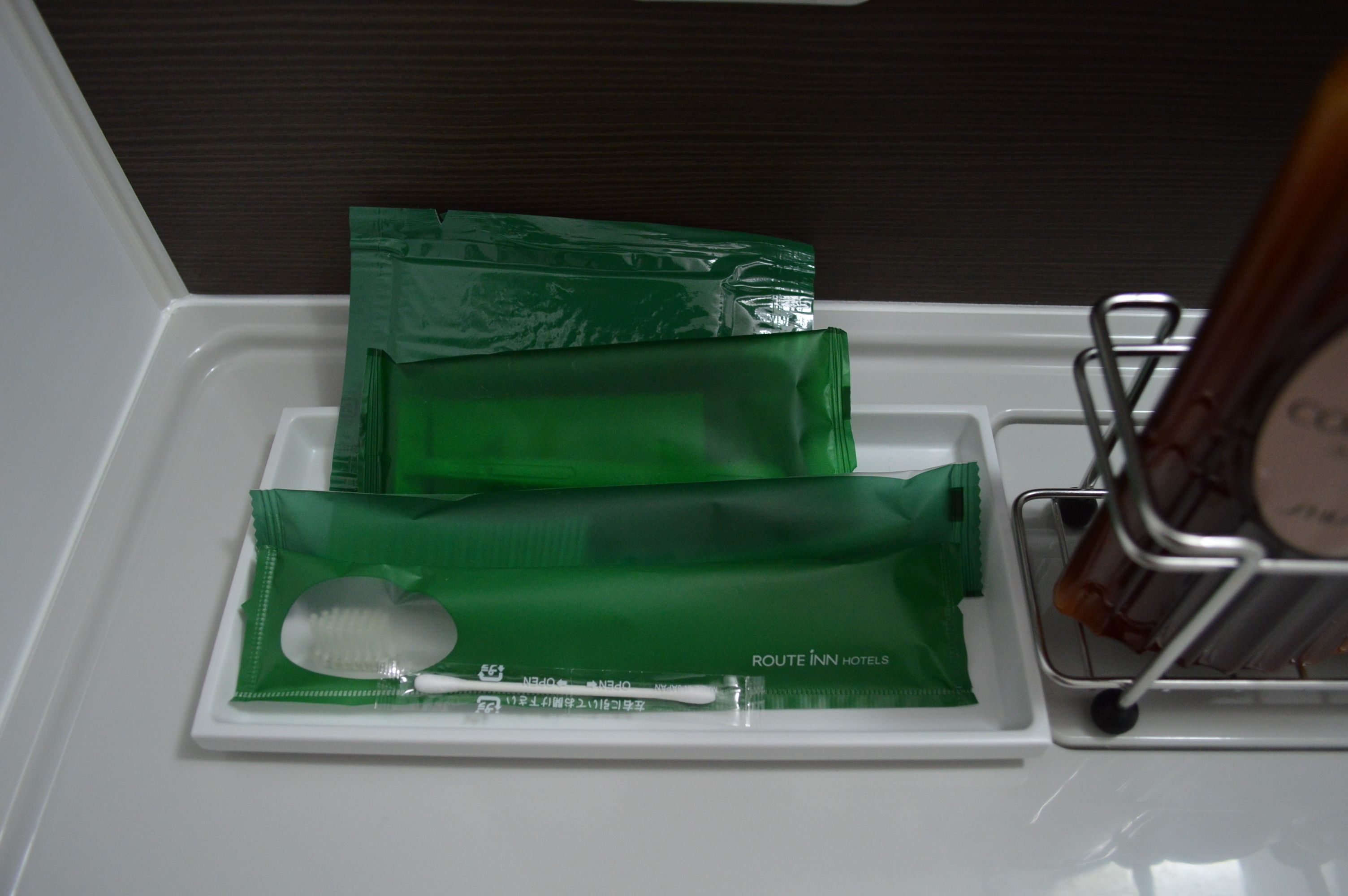 Ein Badezimmer-Waschtisch mit grünen Pflegeprodukten und einer Zahnbürste.