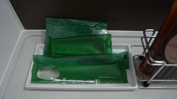 Ein Badezimmer-Waschtisch mit grünen Pflegeprodukten und einer Zahnbürste.