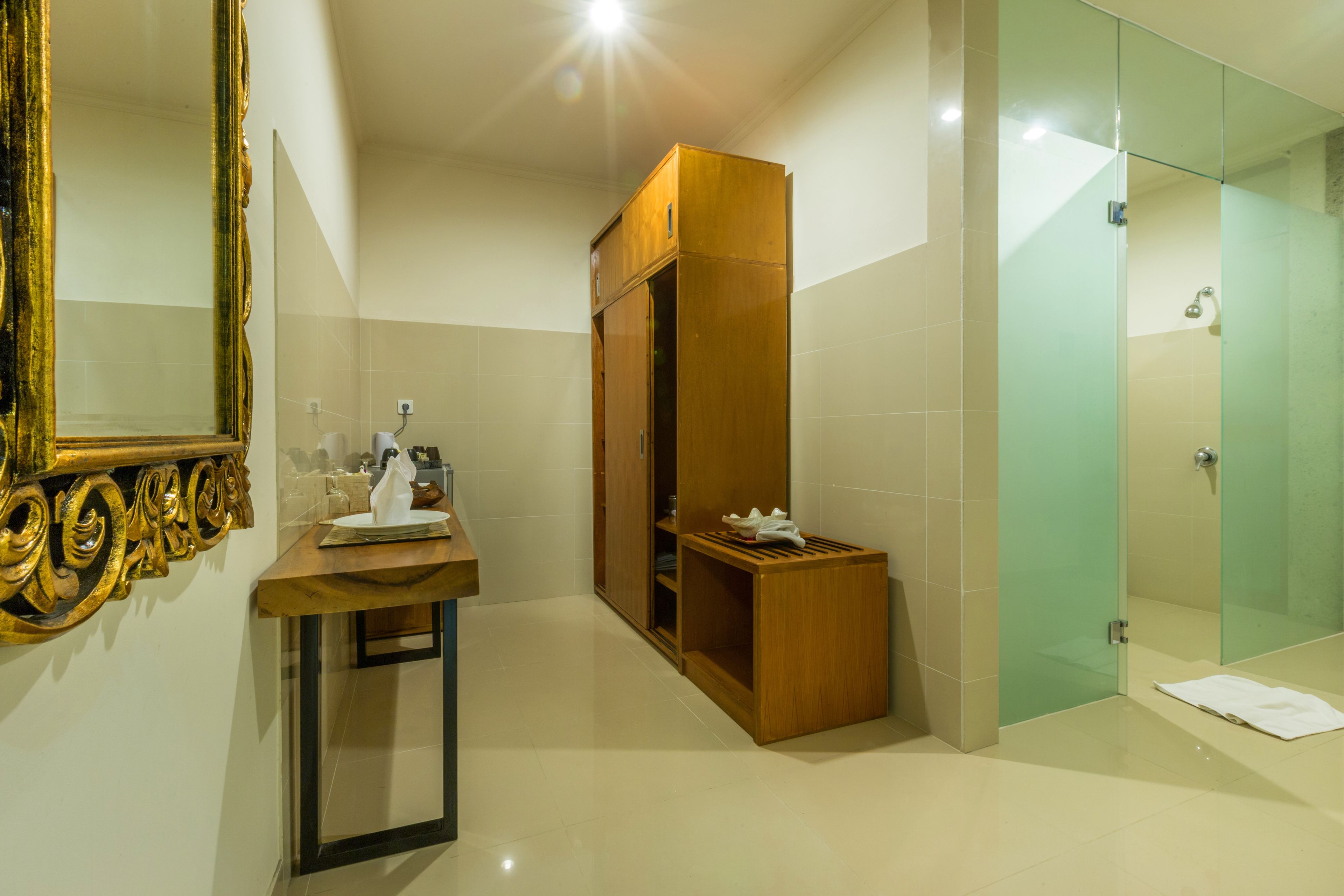 A modern bathroom with a vanity, a mirror, a wooden cabinet, and a glass shower enclosure.