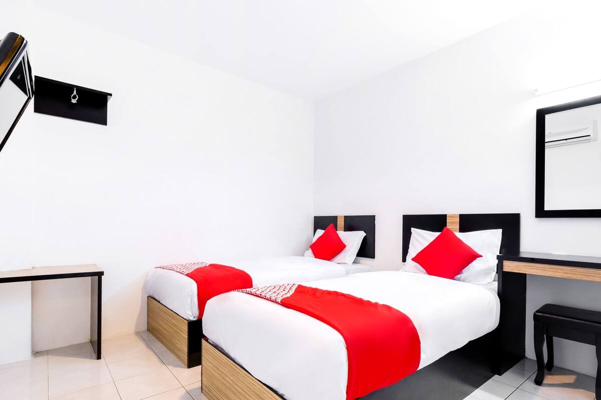 Una habitación de hotel moderna con dos camas, un escritorio y una silla.