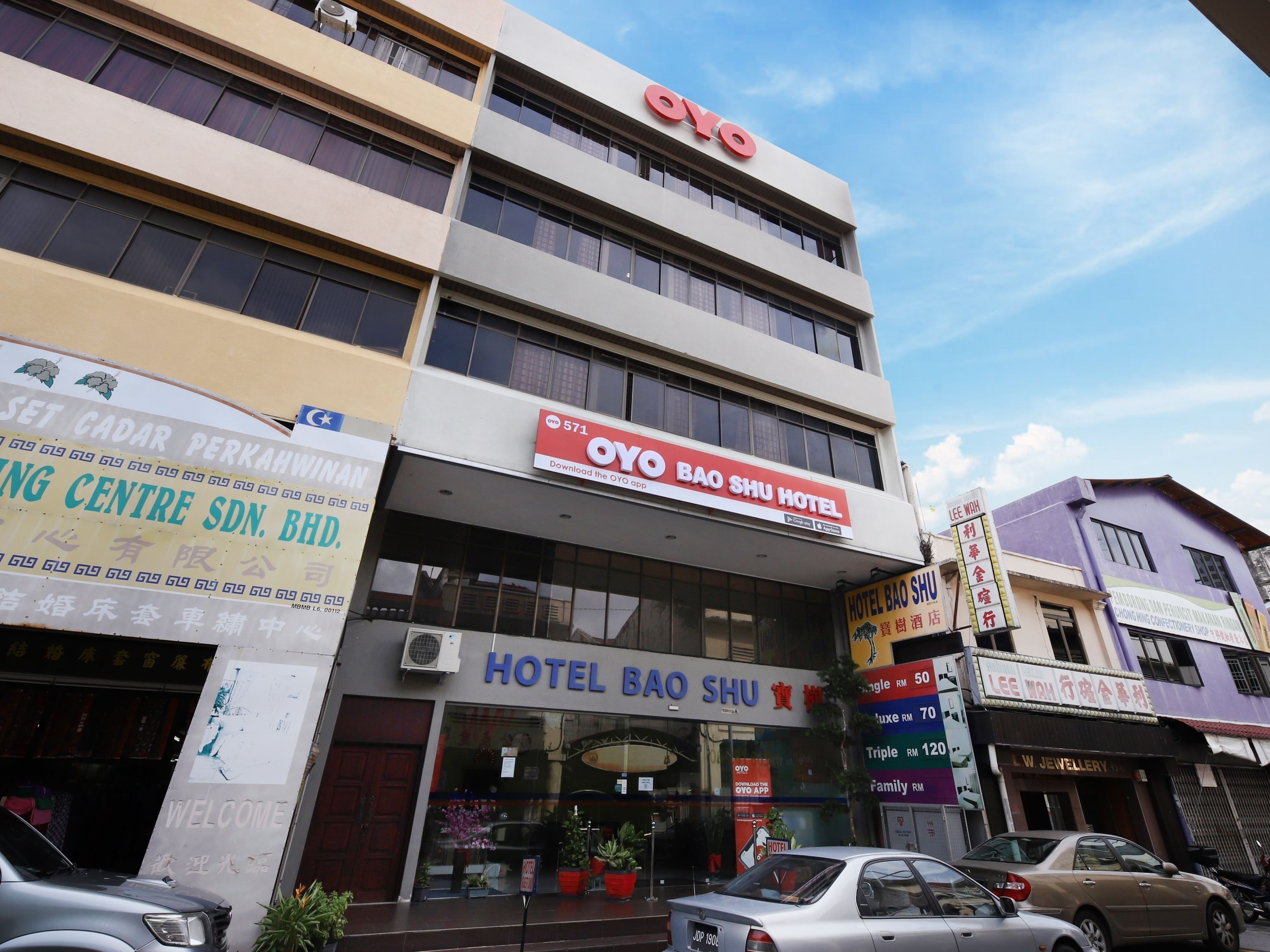 Un hotel con un cartello ben visibile 'OYO', un cartello 'Hotel Bao Shu' e un cartello 'Set Cadar Perkahwinan'.
