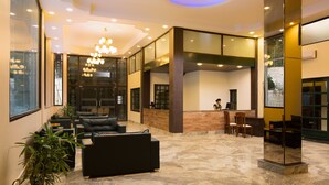 A lobby with a reception desk, seating area, and a chandelier. - Sterling Nainital (Nainital)