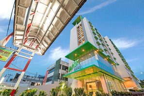 A modern hotel with a prominent 'Prime' sign, large windows, and a green accent on the facade. - Whiz Prime Hotel Balikpapan (Balikpapan)