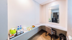 Un baño moderno con un mueble de tocador curvo, un espejo y un perchero para toallas.