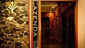 Un muro de piedra con un letrero que dice "AZENDA Suites".