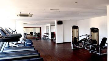 A gym with treadmills, weight machines, and a mirror.
