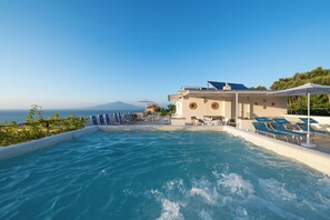 A pool area with lounge chairs and a view of the sea. - Hotel Britannia (Sorrento)