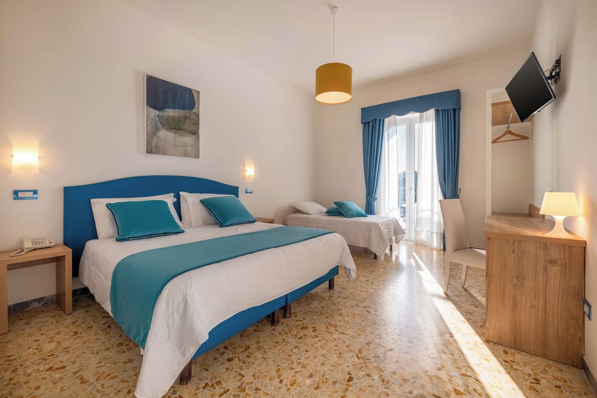 Habitación triple, balcón, vista al mar | Minibar, caja de seguridad en la habitación y escritorio
