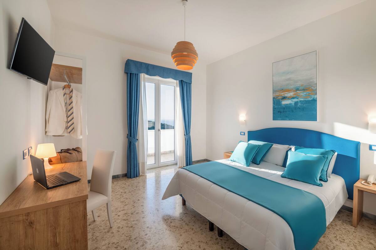 Habitación doble, balcón, vista al mar | Minibar, caja de seguridad en la habitación y escritorio