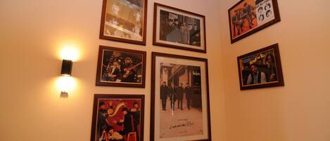 Pared con cuadros enmarcados y una lámpara fijada a la pared.