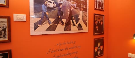 Una pared con cuadros enmarcados y un cartel de los Beatles.