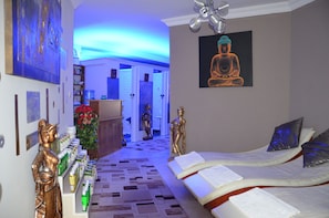 Ein Hotelzimmer mit einem Bett, einem Buddha-Gemälde und einem zur Toilette führenden Gang.