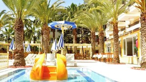 A pool area with palm trees, lounge chairs, and umbrellas. - Çınar Family Suite Hotel (Manavgat)