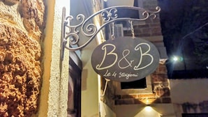 A sign for 'B&B Le 4 Stazioni' hanging from a wrought iron structure. - B&B Le Quattro Stagioni (Agrigento)