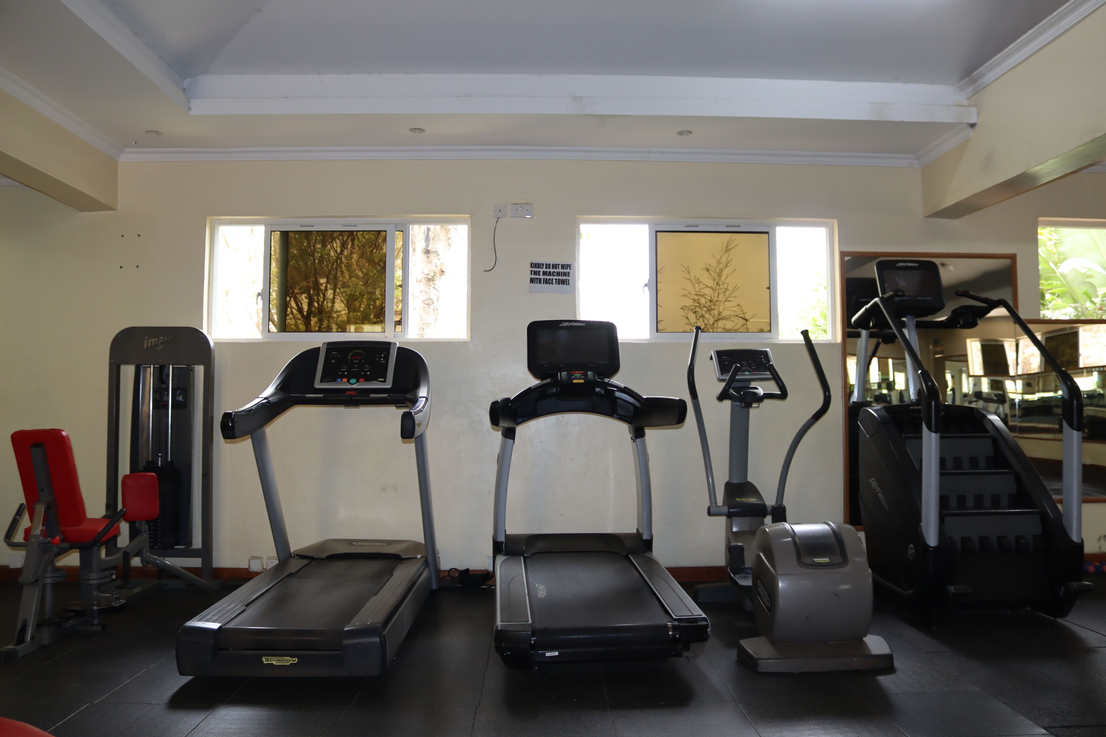 A gym with treadmills, an elliptical, and a stair climber.